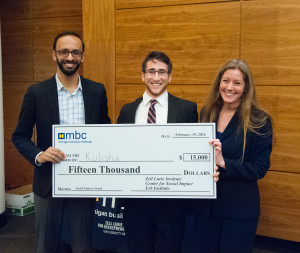 Three smiling people hold large check that reads, "Pay to the order of: Kulisha, $15,000 Fifteen Thousand Dollars, Memo: National Impact Award, Zell Lurie Institute, Center for Social Impact, Erb Institute."