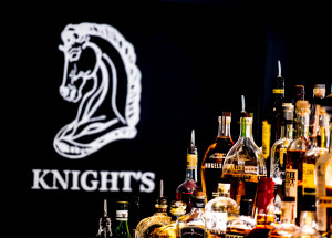 Knight's horse head logo to the left of a large selection of alcohol.
